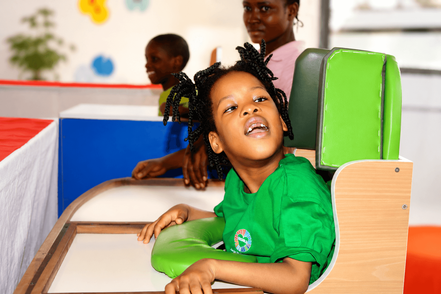 A child at SECHILD's center, supported in an adaptive therapy chair during a session
